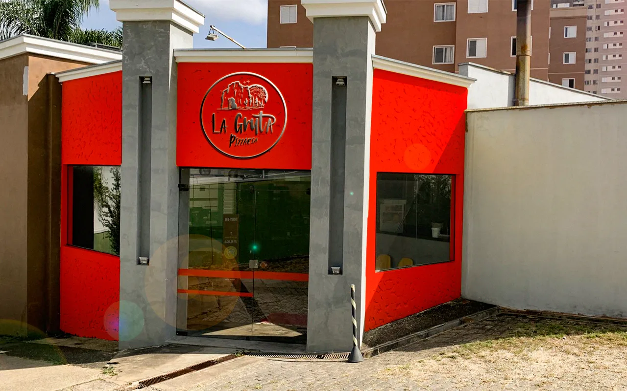 Fachada da La Gruta Pizzaria com a marca aplicada
